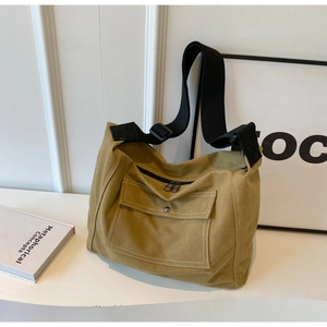 Detailansicht der gelben Segeltuchtasche mit Metallschnallentasche und Kontrastnähten in Weiß