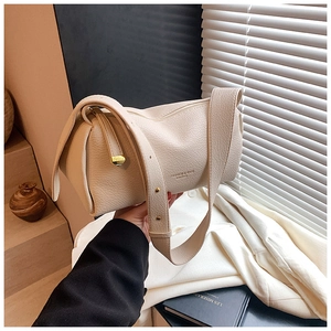 Detail of creamy white pillow crossbody bag showing premium lychee grain leather texture