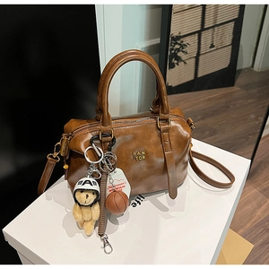 Detail view of a vintage brown leather bowling bag with accessories and logo
