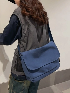 Große dunkelblaue Segeltuch-Umhängetasche an einem Modell für einen lässigen Streetstyle