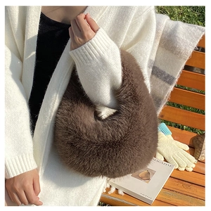 Nahaufnahme einer kaffeebraunen Plüsch-Handtasche aus Kunstpelz im Freien