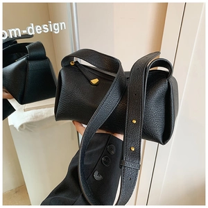 Close-up of black lychee grain leather fold bag with gold hardware and wide strap