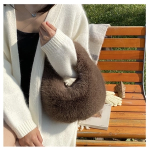 Detail einer dunkelbraunen Webpelz-Handtasche mit flauschiger Textur und Mondform