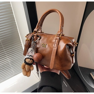 Detail of vintage brown leather baseball bag with PAN TOR logo and teddy bear charm