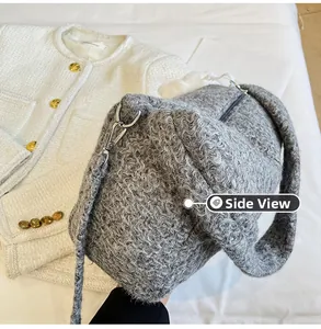 Side view of gray textured teddy fleece cylinder bag with silver zipper and matching strap