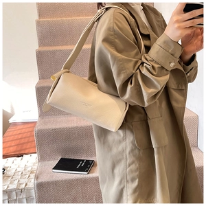 Detail of lychee textured cream boston bag with Fashion & Bags lettering and strap