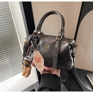 Detail of vintage charcoal grey Boston bag with gold logo, handles, and teddy bear charm