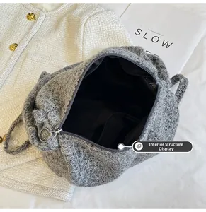 Detail of grey curly faux fur tote bag showing silver zipper and internal pocket