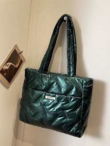 Sac fourre-tout matelassé vert foncé avec étiquette de mode dans un cadre épuré