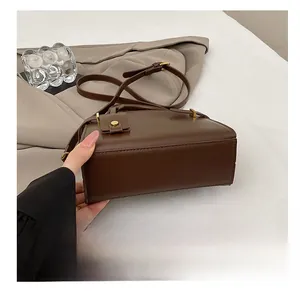 Détail du fond résistant à l'usure et des ferrures dorées de ce sac à bandoulière marron
