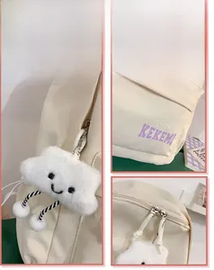 Detail display of cream white backpack with plush cloud charm and purple KEKEMI logo