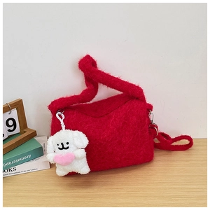 Detail of red plush crossbody bag with cute white dog charm and fluffy shoulder strap