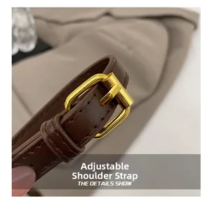 Vue détaillée de la bandoulière réglable en cuir marron foncé avec boucle dorée