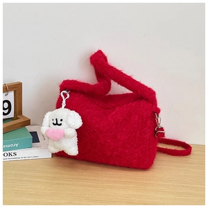 Detail of red plush crossbody bag with soft faux fur texture and cute white puppy charm