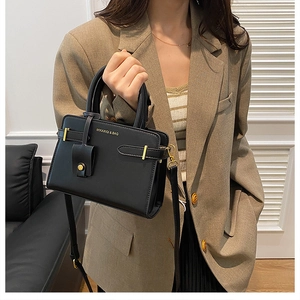 Détail du sac à bandoulière noir élégant avec garnitures dorées et logo de la marque
