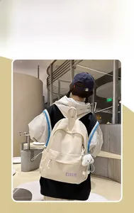 Detail view of cream-colored backpack with cute rabbit charm on a model back