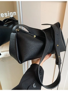 Black lychee leather shoulder bag with gold zipper and unique trapezoid fold design