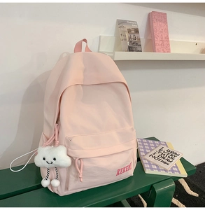 Close-up of pink nylon backpack featuring a cute white plush cloud charm and KEKEMI logo