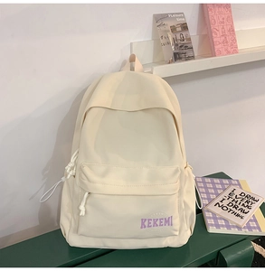 Detail view of cream school backpack showing purple KEKEMI logo and side drawstring