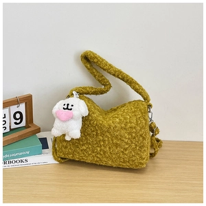 Close-up of curly plush mustard yellow shoulder bag with a cute white dog charm