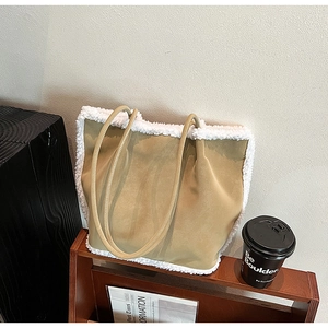Detail of khaki faux suede tote bag featuring white faux shearling trim and slim shoulder straps