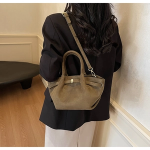 Braune Retro-Tasche aus mattem Wildleder als Umhängetasche für Damen am Modell gezeigt