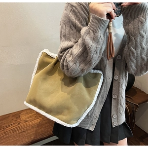 Olive green suede tote bag with white faux fur trim styled with a knitted cardigan