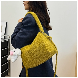 Detail of yellow fuzzy shoulder bag with cute white puppy pendant and wide strap