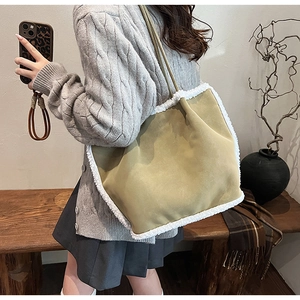 Detail of suede tote bag with white faux fur trim and long shoulder straps for autumn winter