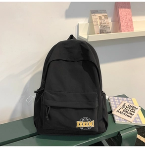 Detailed close-up of a minimalist black nylon backpack featuring the yellow KEKEMI logo