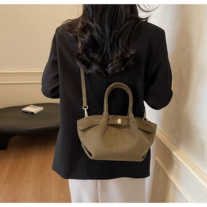 Braune Wildleder-Umhängetasche an einem Modell in minimalistischem Innenraum gezeigt