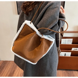 Detailed side view of brown faux suede tote bag with fluffy white lamb wool trim finish