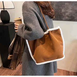 Detail of caramel suede tote bag with white faux shearling trim and long shoulder strap