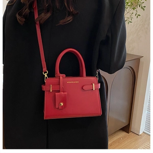 Gros plan du sac à main rouge élégant avec détails dorés et logo de la marque