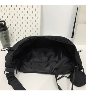 Internal view of the black crossbody bag showing spacious main compartment and zipper pocket