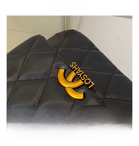 Detail of black quilted leather bag with gold metal clasp and premium stitching texture