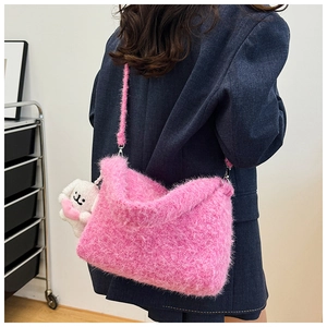 Detail of pink faux fur crossbody bag with cute white puppy plush charm on suit