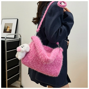 Macro shot of fluffy pink plush crossbody bag with a cute white puppy charm accessory