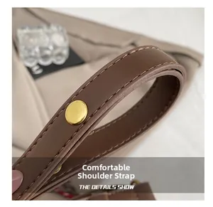 Close-up of brown leather shoulder strap with gold-tone hardware on a leopard bucket bag