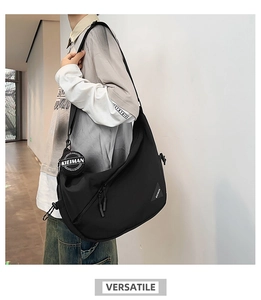 Detail of black nylon dumpling bag with adjustable strap and small round coin purse