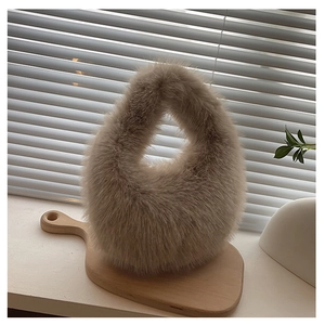 Nahaufnahme einer flauschigen Kunstfell-Handtasche in Hellbraun auf einem Holztablett