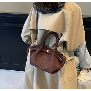 Seitenansicht des Modells mit brauner Wildleder-Tote-Bag und beigem Mantel