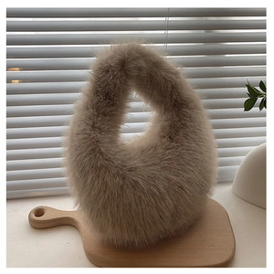 Detail einer weichen Plüsch-Handtasche mit rundem Griff auf einem Holztablett