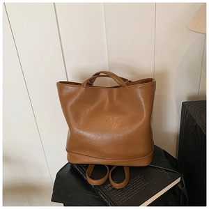 Detail der braunen Ledertextur auf einer minimalistischen Tote- und Rucksack-Kombitasche