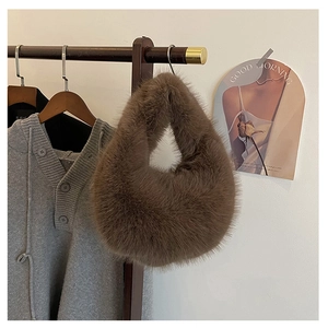 Detailansicht eines dunkelbraunen Plüschschals aus Kunstpelz auf einem Holzkleiderbügel