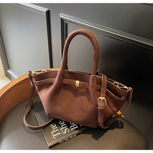 Detailaufnahme der braunen Veloursleder-Tote Bag mit goldenen Metallbeschlägen
