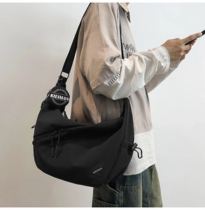 Detail view of black crossbody dumpling bag with round pouch and adjustable drawstrings