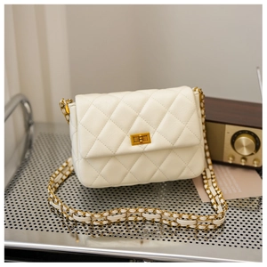 Close-up of cream quilted leather bag with classic diamond stitching and gold chain strap