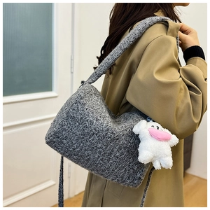 Detail of grey teddy fleece crossbody bag with a cute white puppy plush charm