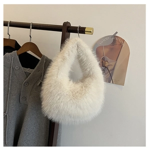 Detail der weißen Kunstpelz-Handtasche am Holzbügel in stilvoller Lifestyle-Umgebung